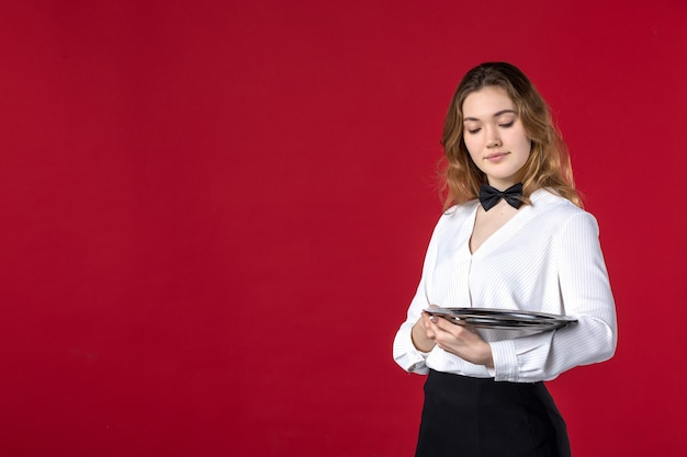 ambitieuze serveerster vrouw vlinder op de nek en met dienblad op rode achtergrond