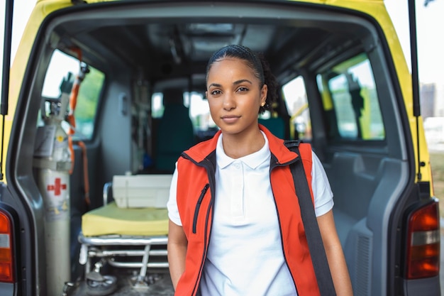 Gratis foto ambulancemedewerker komt uit de achterkant van een ambulance met haar noodrugzak en monitor voor vitale functies