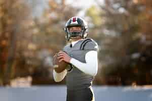 Gratis foto american football-speler in uniforme training op het veld