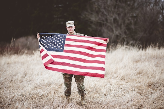 Gratis foto amerikaanse soldaat met de amerikaanse vlag