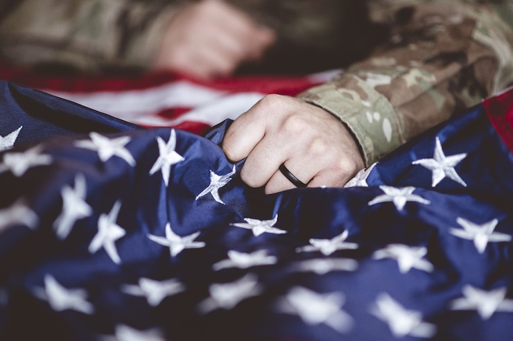 Gratis Foto amerikaanse soldaat rouwt en bidt met de amerikaanse vlag voor hem
