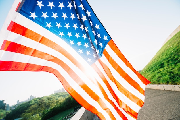 Gratis foto amerikaanse vlag met weg en zonneschijn