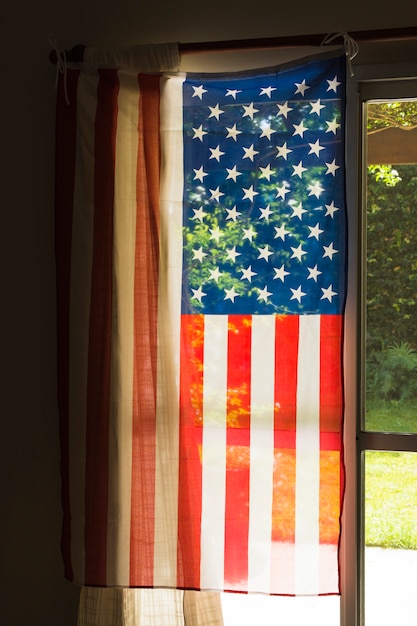 Amerikaanse vlag van de vs hangt op het glasvenster