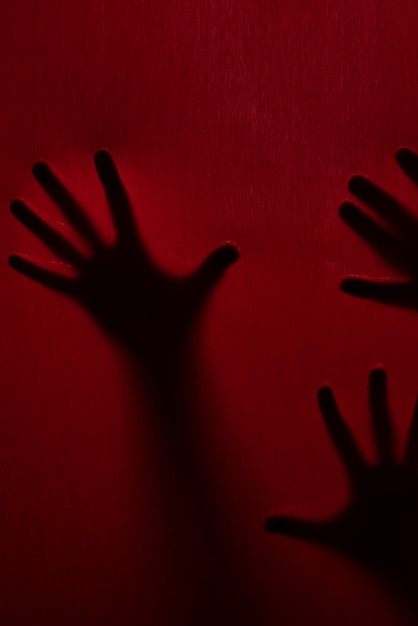 Gratis foto angstaanjagende handen silhouetten in de studio