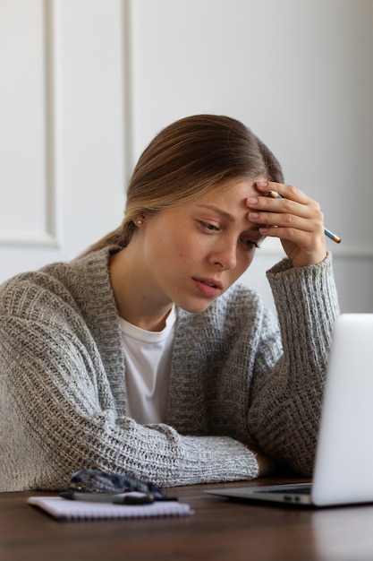 Angstige vrouw aan bureau medium shot