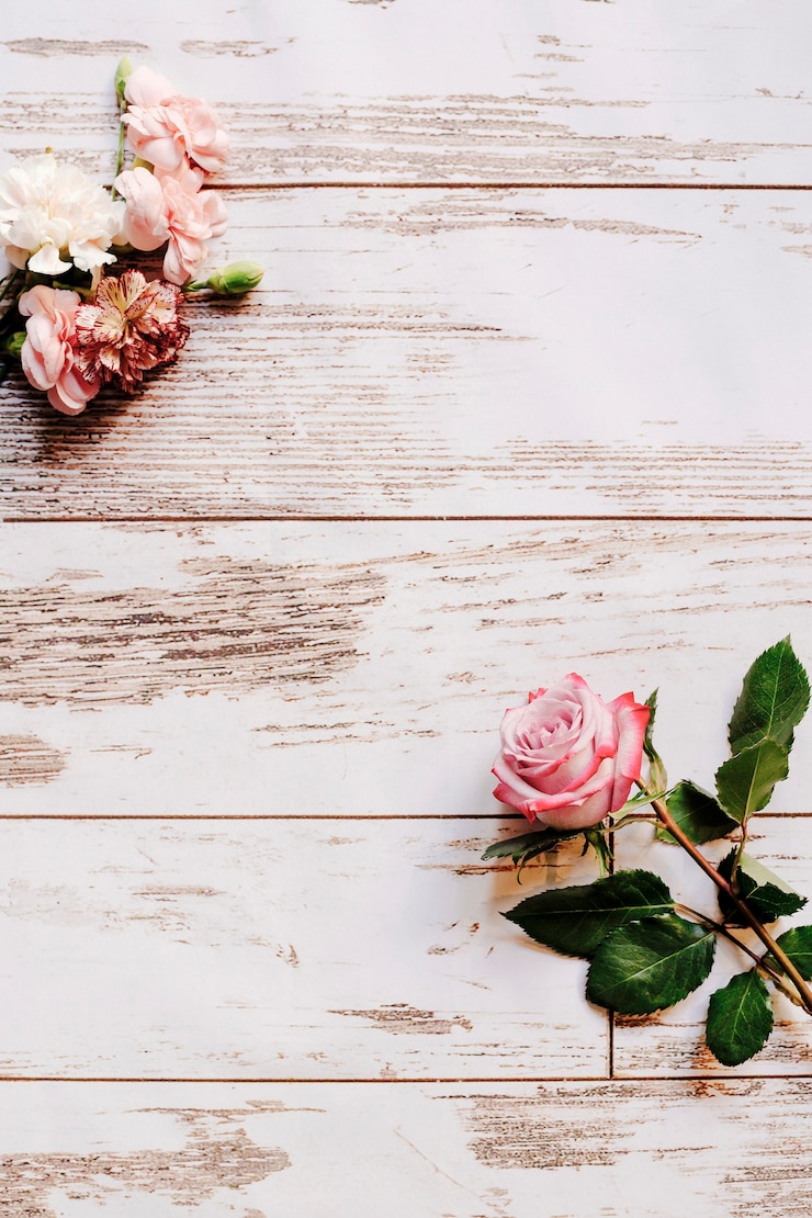 Gratis Foto anjerbloemen en roze roos op oude houten tafel