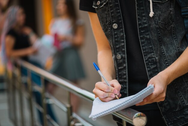 Anonieme student schrijven in notitieblok