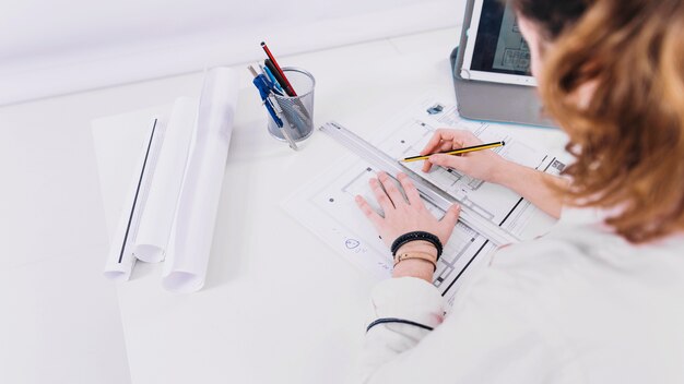 Anonieme vrouw die blauwdruk ontwikkelt