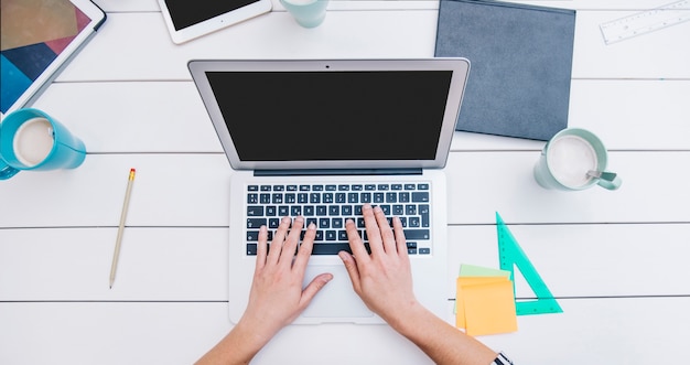 Anonieme werknemer te typen op de laptop op het bureau