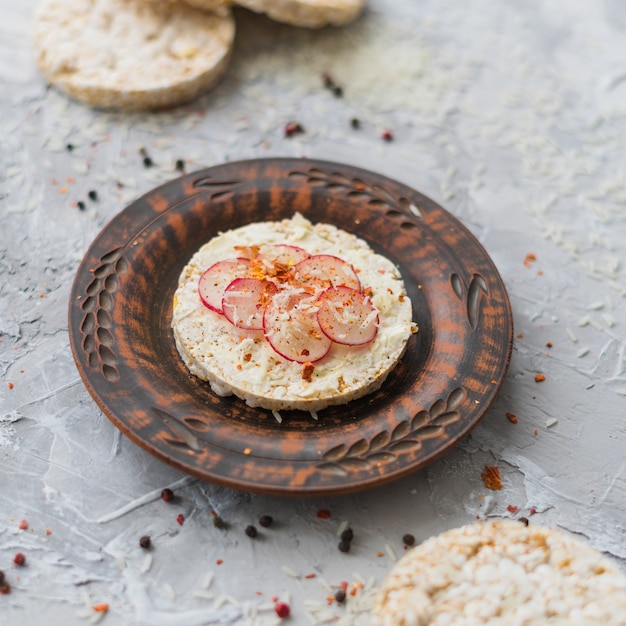 Antieke decoratieve plaat met zelfgemaakte gepofte rijstwafel met plakjes raap