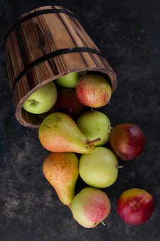Appel, perzik en peren uit een houten emmer