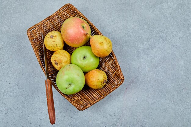 Appels en peren op de mand met mes.