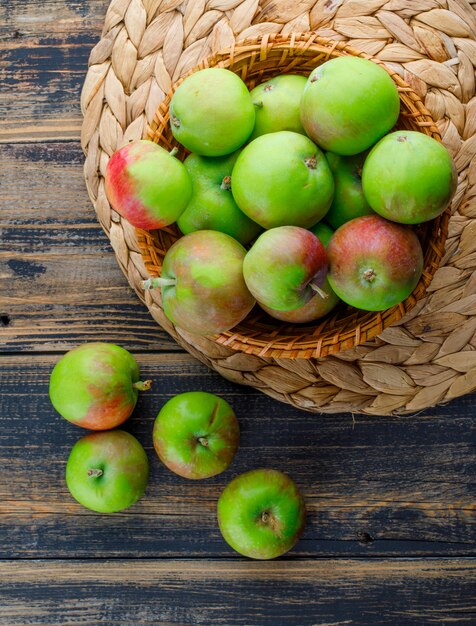 Appels in een rieten mand op houten en placematachtergrond. bovenaanzicht.