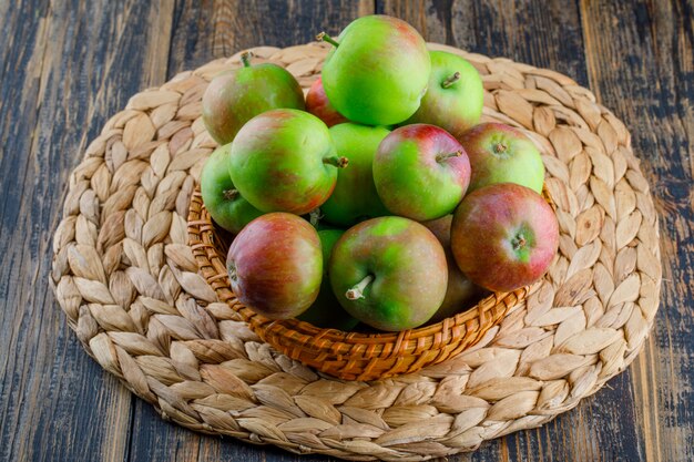 Appels in een rieten mand op houten en placematachtergrond. hoge kijkhoek.