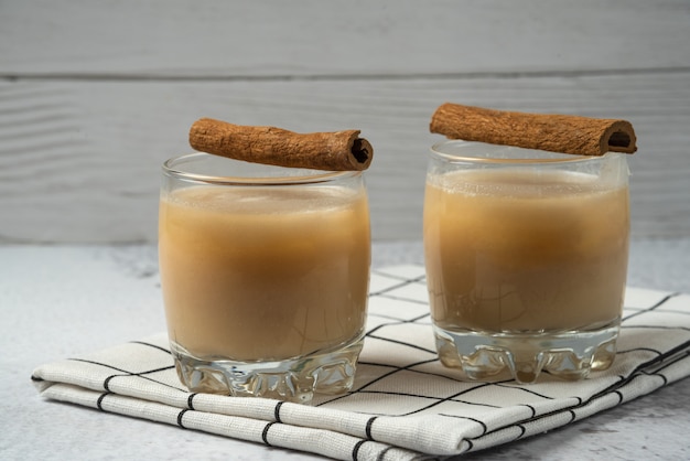 Appelsap in de beker met kaneelsmaak op de geruite handdoek