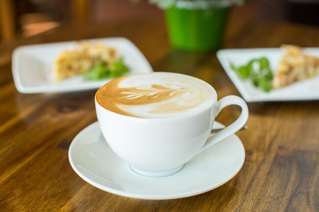 Appeltaart en cappuccino op een houten tafel