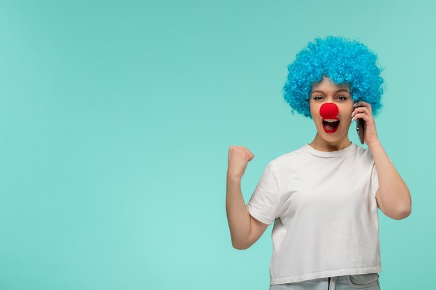 April dwazen dag gelukkig meisje vuist teken ja ik deed het met rode neus clown kostuum blauw haar