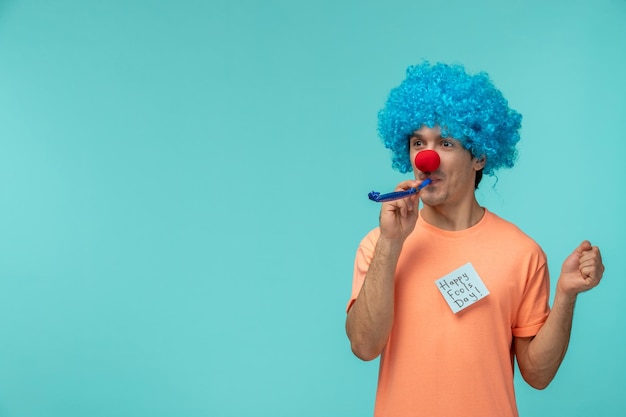 Gratis foto april dwazen dag kerel rode neus clown grappig bedrijf blauw fluitje blauw haar blauw post-it sticker notitie