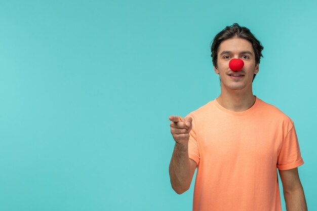 April dwazen dag kerel serieus gezicht rode neus clown kostuum grappige vinger wijzend naar voren