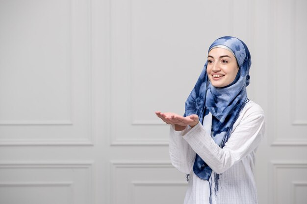 Arabisch meisje gewikkeld hoofd in blauw witte hijab mooie moslim schattige jongedame die zegen geeft