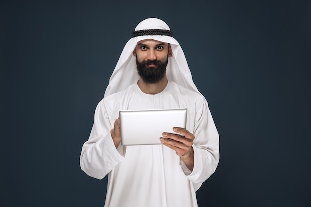 Gratis foto arabische saoedische zakenman op donkerblauwe studioachtergrond