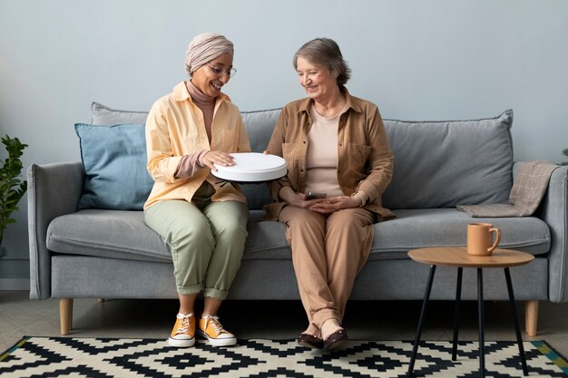 Arabische vrouw die senior vrouw leert om led-lamp met smartphone te gebruiken