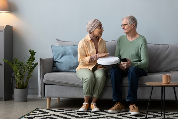 Arabische vrouw leert senior man om led-lamp met smartphone te gebruiken