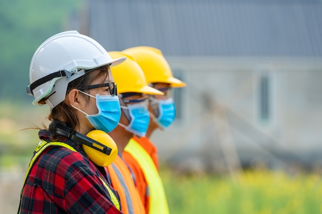 Arbeider die beschermend masker draagt om tegen covid-19 in de fabriek te beschermen, veiligheidscontrole tegen epidemieën in bouwwerfconcept.