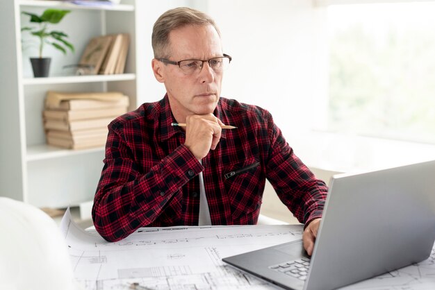 Architect die zijn project op laptop voorbereidt