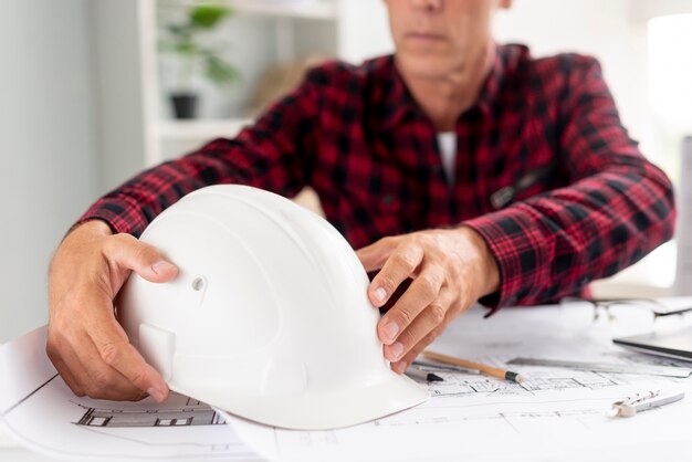Architect die zijn veiligheidshelm houdt
