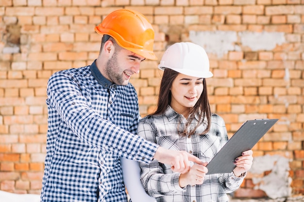 Architect voor bakstenen muur met klembord