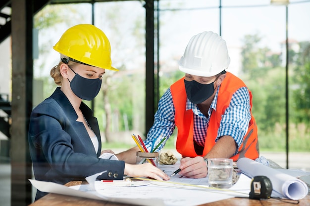 Architecten in gezichtsmasker plannen constructie in nieuw normaal