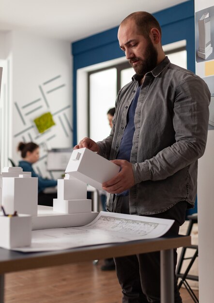 Architectuurdeskundige persoon die naar maquette kijkt