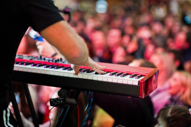 Artiesten spelen op audiopiano op het podium in een concertzaal achter mensen