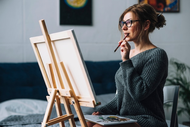 Artistieke vrouw die op canvas staart