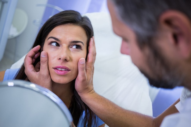 Arts die de huid van patiënten na cosmetische behandeling controleert