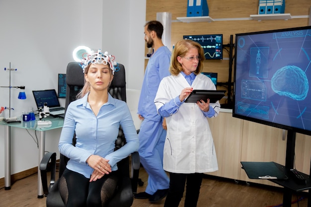 Arts die de procedure volgt om de hersenen van een meisje te scannen. Neurologie scanning headset
