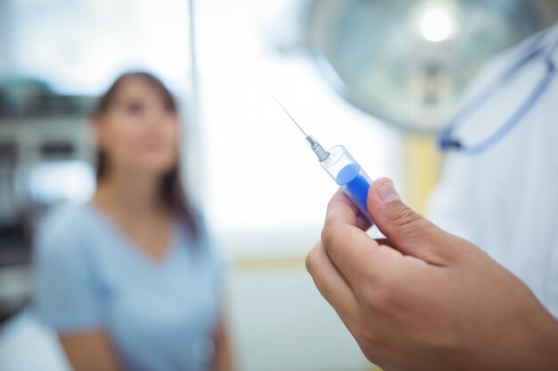 Arts die een spuit voorbereidt om een injectie te geven