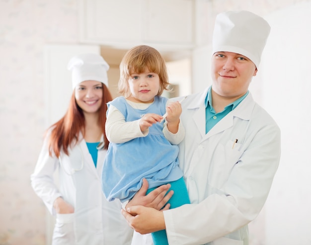 Arts en verpleegkundige met een kind in de kliniek