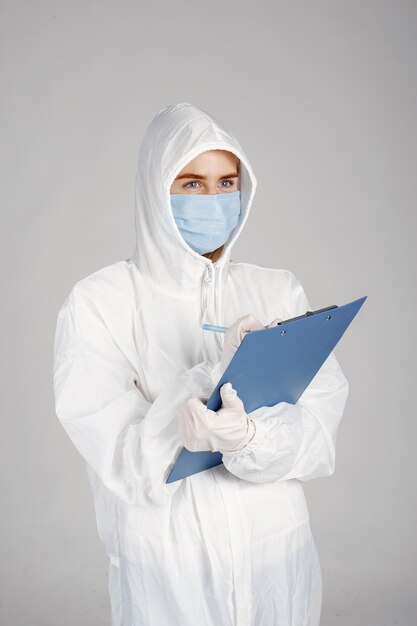 Arts in een medisch masker. Coronavirus-thema. Ge oleerd over witte muur. Vrouw in een beschermend pak.