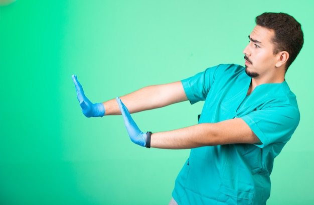 Arts in groen uniform en handmaskers die zich van gevaar af bewegen.