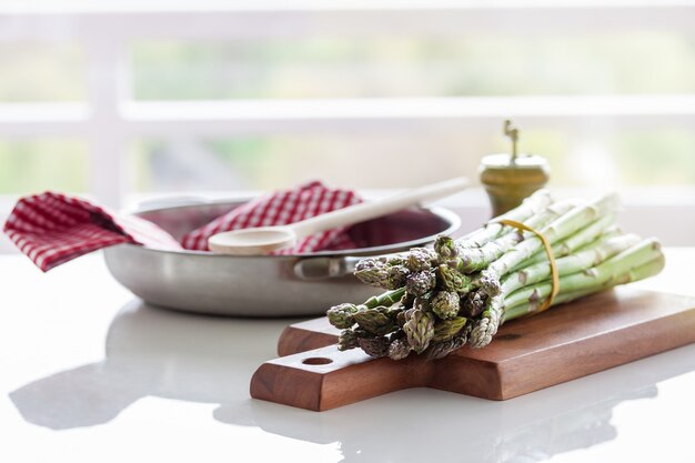 Asperges op een houten plank in de buurt van een doek