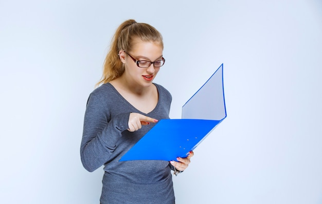 Assistent die de blauwe rapportmap opent en controleert.