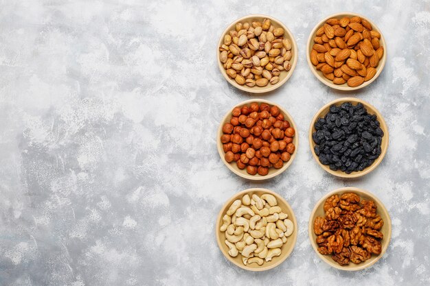 Assortiment noten in keramische platen. Cashewnoten, hazelnoten, walnoten, pistache, pecannoten, pijnboompitten, pinda, rozijnen. Bovenaanzicht