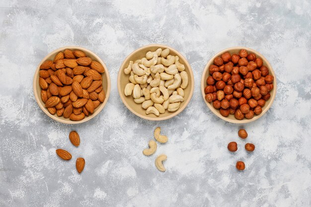 Assortiment noten in keramische platen. Cashewnoten, hazelnoten, walnoten, pistache, pecannoten, pijnboompitten, pinda, rozijnen. Bovenaanzicht