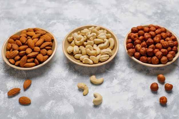 Assortiment noten in keramische platen. cashewnoten, hazelnoten, walnoten, pistache, pecannoten, pijnboompitten, pinda, rozijnen. bovenaanzicht