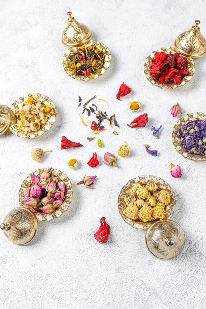 Assortiment van droge thee in gouden vintage mini bordjes. Thee soorten
