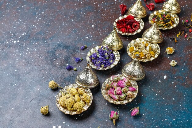 Assortiment van droge thee in gouden vintage mini bordjes. Thee soorten