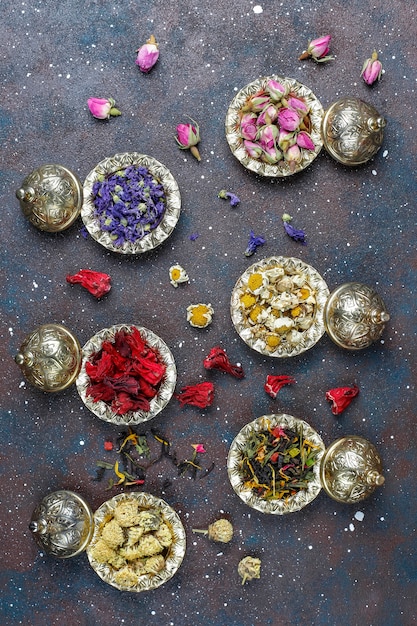 Gratis foto assortiment van droge thee in gouden vintage mini bordjes. thee soorten