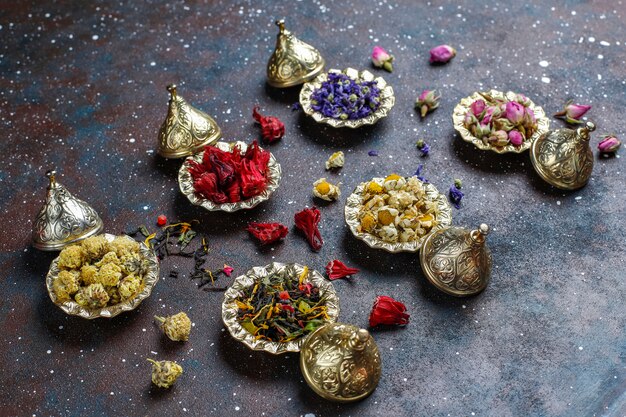 Assortiment van droge thee in gouden vintage mini bordjes. Thee soorten